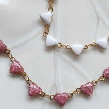 Load image into Gallery viewer, Enamel white and pink option colors on the hearts with 18K Gold with a Stainless Steel Base to ensure it is hypoallergenic and tarnish-resistant with water and sweat.