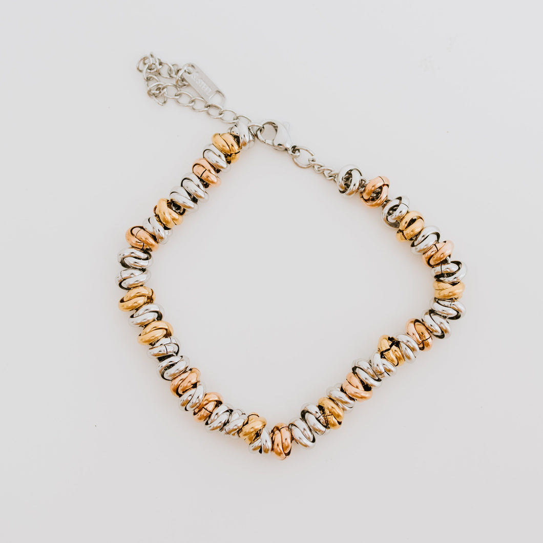 Like a bouquet of flowers that is composed of a variety of colors so is the Bouquet Bracelet. It is made up of ringlets of Gold, Silver, and Rose Gold. The perfect bracelet to tie in when mixing different color metals in one look.