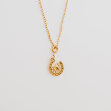 Load image into Gallery viewer, This horseshoe necklace with horse in the middle is the perfect cowgirl necklace. Available in 18k gold pvd stainless steel. 
